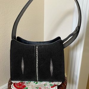 Black leather bag with genuine stingray inlay .